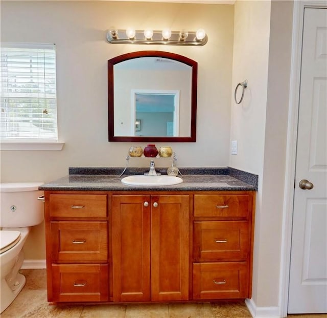 2300 Albany Ave, Waycross, GA 31503 - bathroom featuring vanity, toilet, tile patterned floors, and baseboards