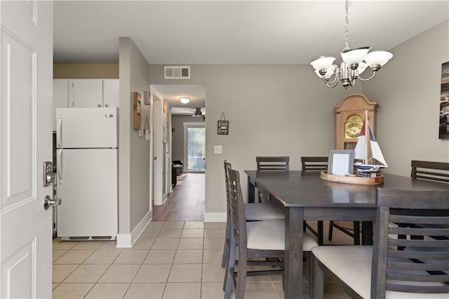 dining room featuring light tile patterned floors and ceiling fan with notable chandelier