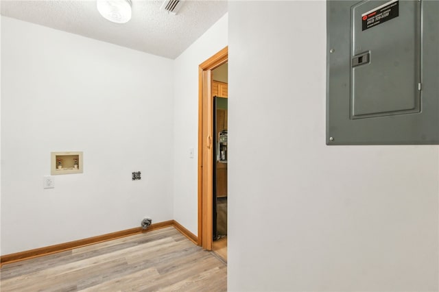 70 Buntin St, Woodbine, GA 31569 - laundry room featuring light wood-type flooring, electric panel, hookup for a washing machine, and a textured ceiling