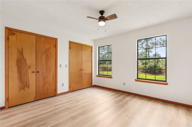 70 Buntin St, Woodbine, GA 31569 - unfurnished bedroom featuring multiple closets, light wood-style flooring, and a ceiling fan