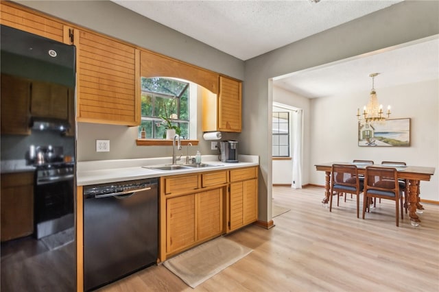 70 Buntin St, Woodbine, GA 31569 - kitchen featuring black dishwasher, light wood-style flooring, light countertops, healthy amount of natural light, and a textured ceiling