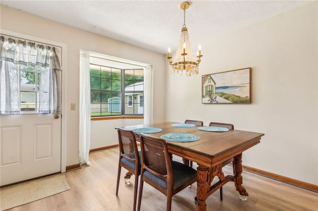 70 Buntin St, Woodbine, GA 31569 - dining space featuring a chandelier, light wood-style flooring, and a textured ceiling