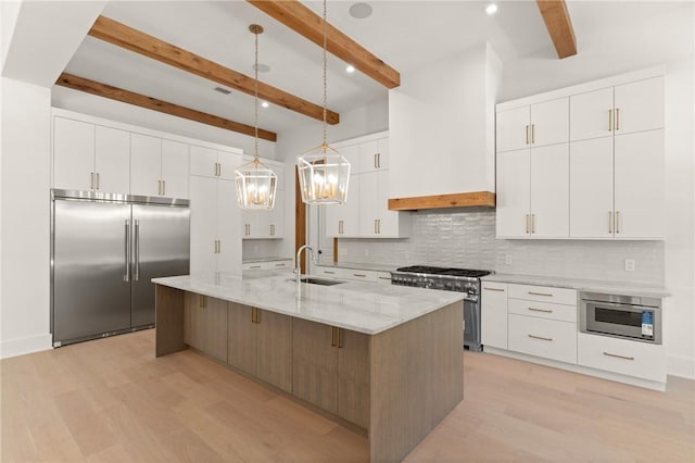 104 Point Ln, Saint Simons Island, GA 31522 - kitchen featuring premium appliances, light wood-type flooring, backsplash, beamed ceiling, and white cabinets