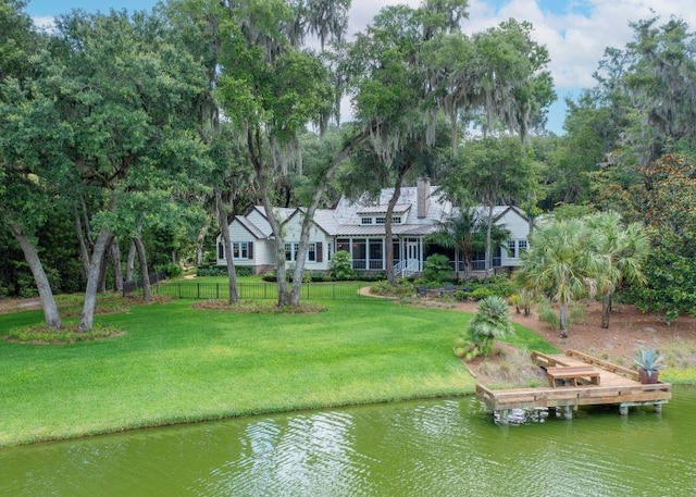 view of dock with a yard and a water view