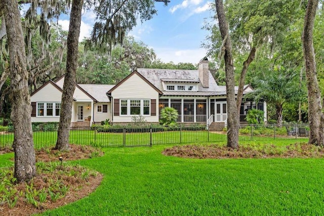 view of front facade with a sunroom and a front lawn