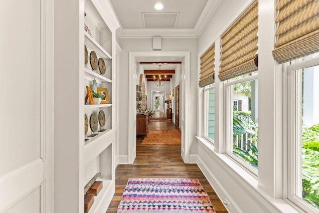 hall with a healthy amount of sunlight, dark hardwood / wood-style flooring, and ornamental molding