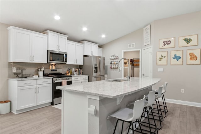 129 Chinquapin Dr, Saint Marys, GA 31558 - kitchen with appliances with stainless steel finishes, a sink, backsplash, light wood-style floors, and a center island with sink