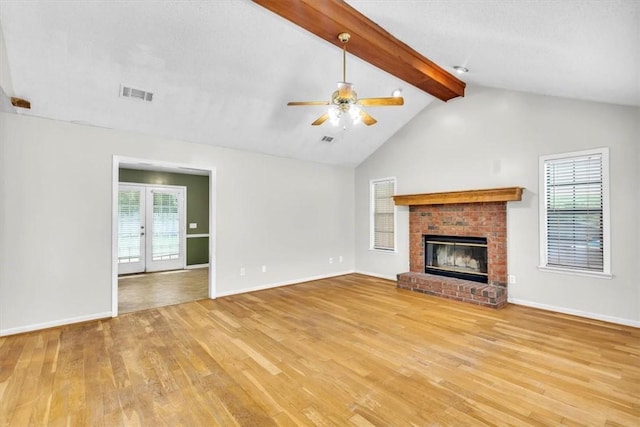 122 Tyson Ln, Allenhurst, GA 31301 - unfurnished living room featuring light wood-style flooring, beam ceiling, ceiling fan, a fireplace, and french doors