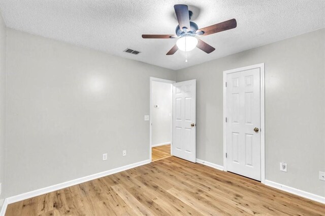 122 Tyson Ln, Allenhurst, GA 31301 - unfurnished bedroom featuring light wood-type flooring, a textured ceiling, and ceiling fan