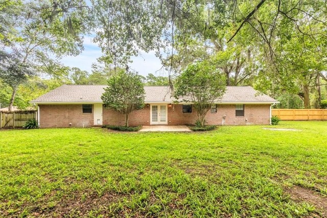 122 Tyson Ln, Allenhurst, GA 31301 - rear view of property featuring french doors, a fenced backyard, a patio area, and brick siding