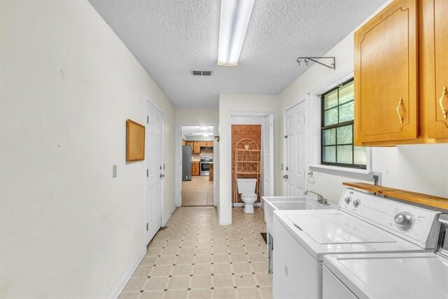 122 Tyson Ln, Allenhurst, GA 31301 - laundry area with separate washer and dryer, light floors, a textured ceiling, and cabinet space