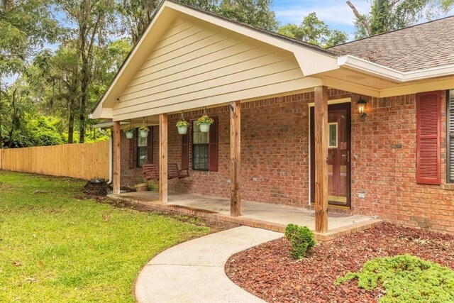 122 Tyson Ln, Allenhurst, GA 31301 - entrance to property featuring brick siding, roof with shingles, and a porch
