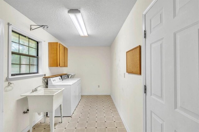 122 Tyson Ln, Allenhurst, GA 31301 - washroom with a textured ceiling, washing machine and clothes dryer, and cabinet space