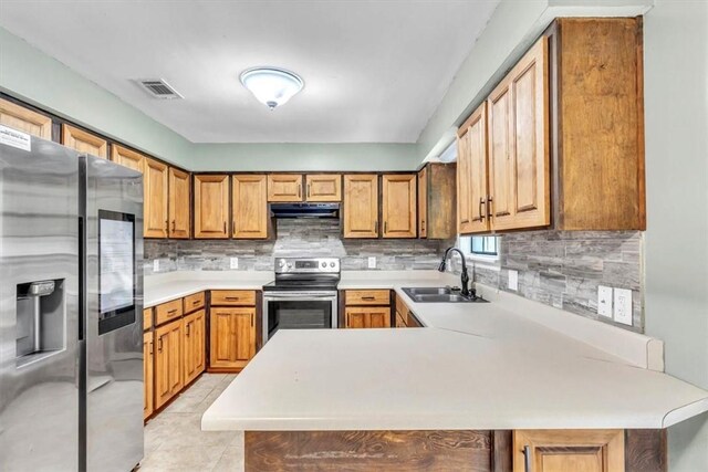122 Tyson Ln, Allenhurst, GA 31301 - kitchen featuring stainless steel appliances, under cabinet range hood, light countertops, backsplash, and a peninsula