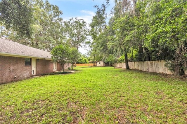 122 Tyson Ln, Allenhurst, GA 31301 - fenced backyard featuring a storage unit