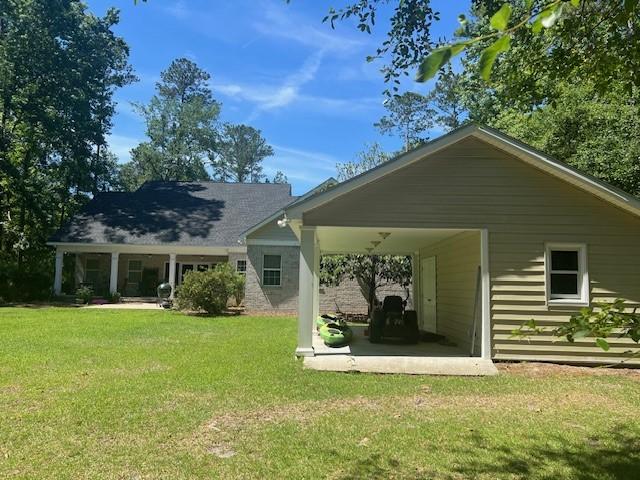 1186 Winterberry Ct NE, Townsend, GA 31331 - back of property featuring a yard and a patio area