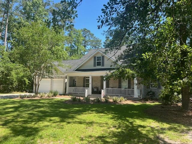 1186 Winterberry Ct NE, Townsend, GA 31331 - view of front of property featuring covered porch, a garage, and a front yard