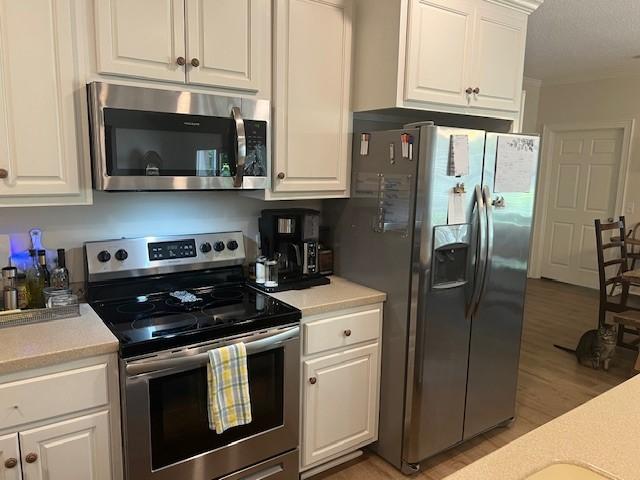 1186 Winterberry Ct NE, Townsend, GA 31331 - kitchen featuring stainless steel appliances, light countertops, and white cabinets