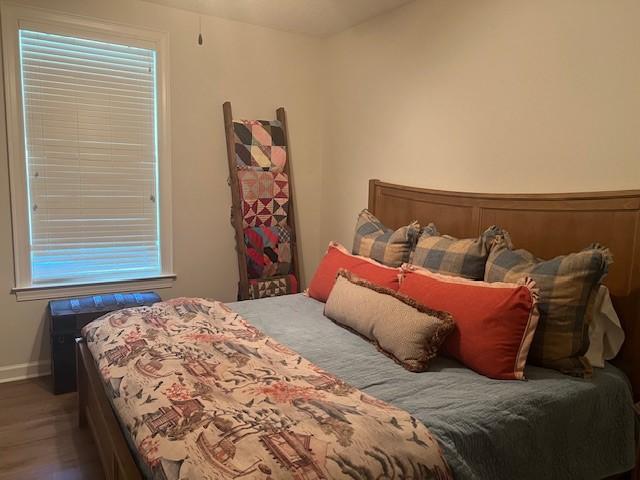 1186 Winterberry Ct NE, Townsend, GA 31331 - bedroom featuring baseboards, wood finished floors, and multiple windows