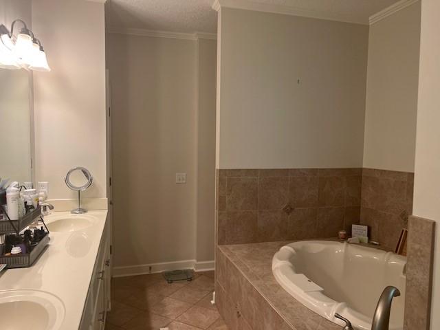 1186 Winterberry Ct NE, Townsend, GA 31331 - full bath featuring double vanity, tile patterned floors, a garden tub, baseboards, and ornamental molding