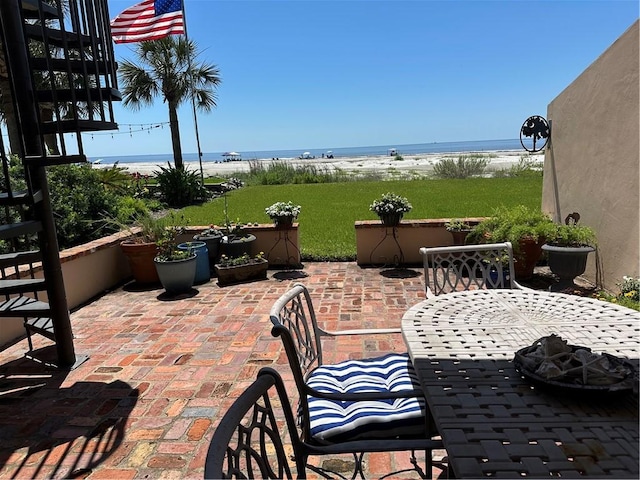 view of patio with a water view and outdoor dining space