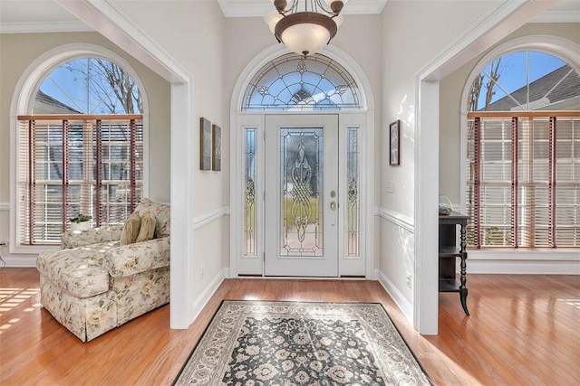 entryway with hardwood / wood-style floors and crown molding