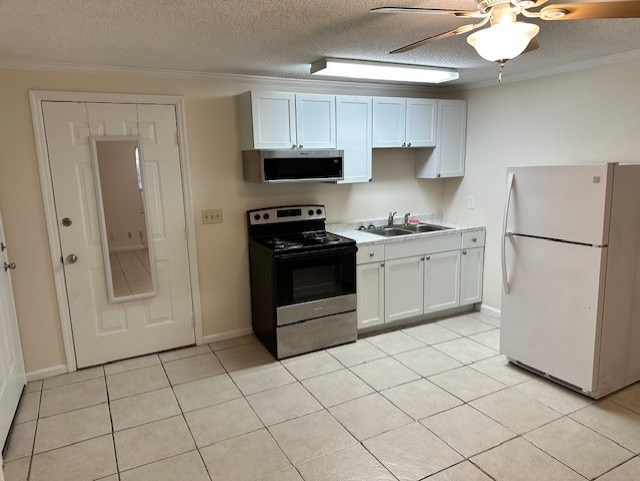 kitchen with a ceiling fan, stainless steel appliances, light countertops, white cabinetry, and a sink