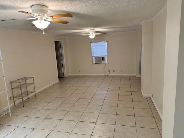 spare room with light tile patterned floors, ceiling fan, baseboards, and a textured ceiling