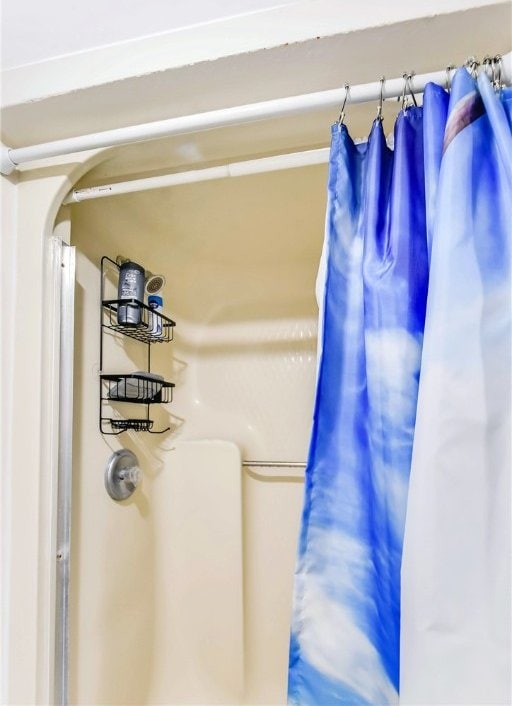 interior details featuring a shower with curtain