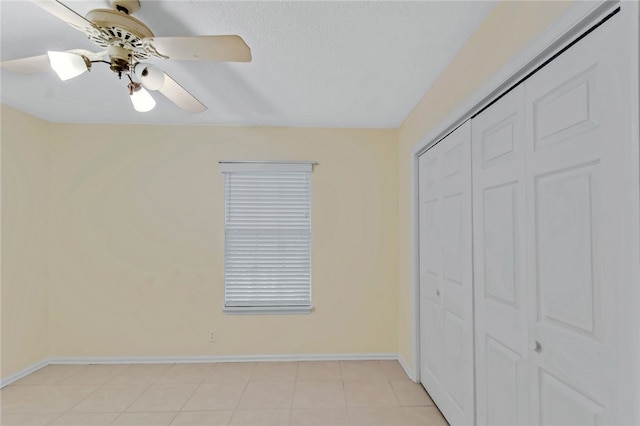 unfurnished bedroom with ceiling fan and a closet