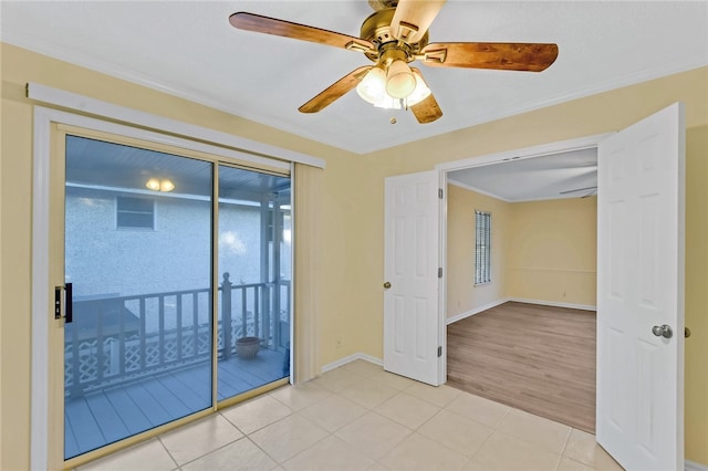 spare room with a ceiling fan, crown molding, baseboards, and light tile patterned floors