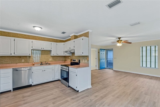 kitchen featuring backsplash, stainless steel appliances, crown molding, light countertops, and a sink