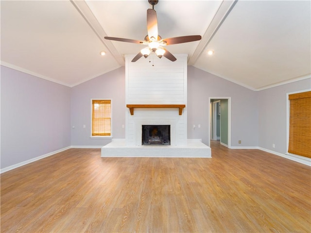 unfurnished living room with ceiling fan, a brick fireplace, lofted ceiling with beams, and light hardwood / wood-style floors