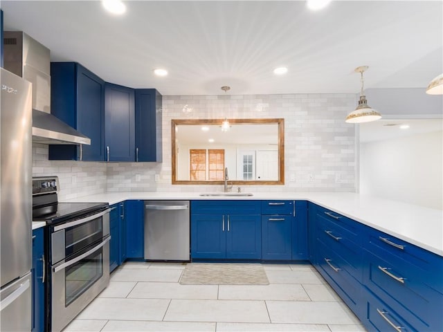 kitchen with blue cabinets, sink, tasteful backsplash, appliances with stainless steel finishes, and pendant lighting