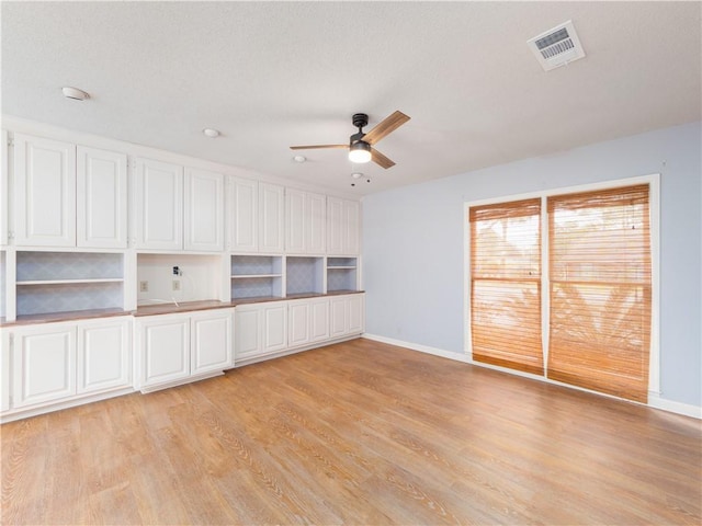 unfurnished room featuring ceiling fan, light hardwood / wood-style floors, and a textured ceiling