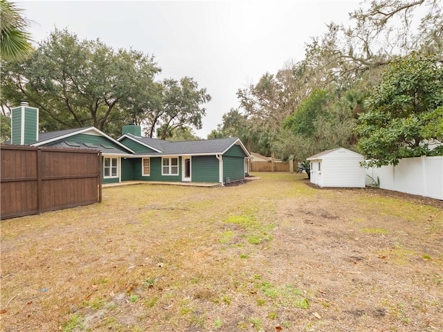 rear view of property featuring a lawn and a shed