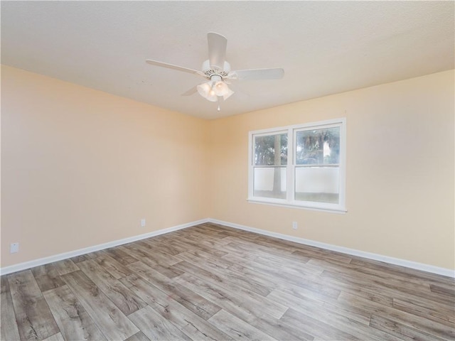 spare room with ceiling fan and light wood-type flooring