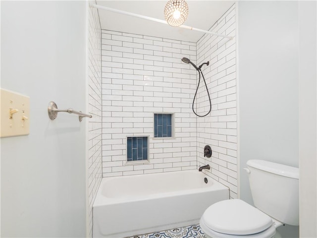 bathroom featuring tiled shower / bath combo and toilet