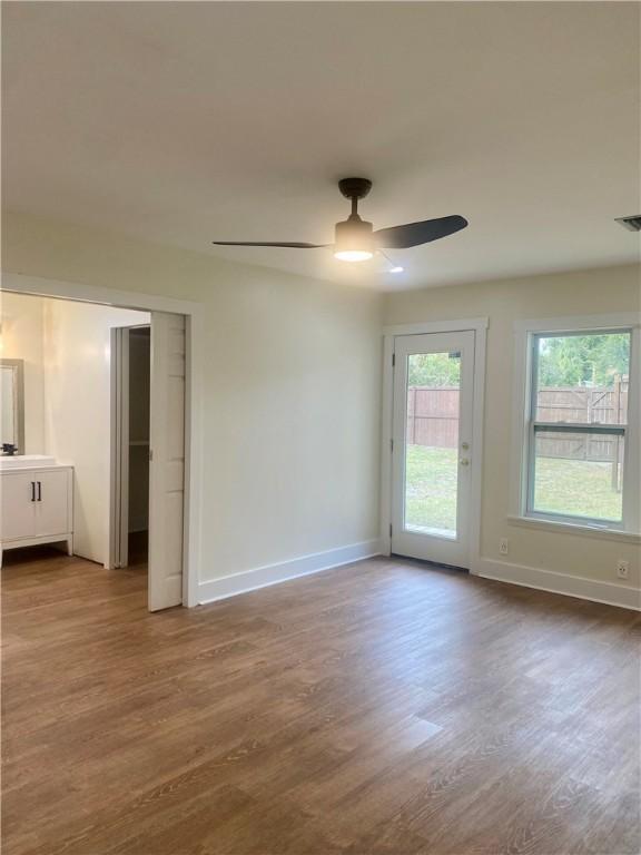 empty room with ceiling fan and hardwood / wood-style floors