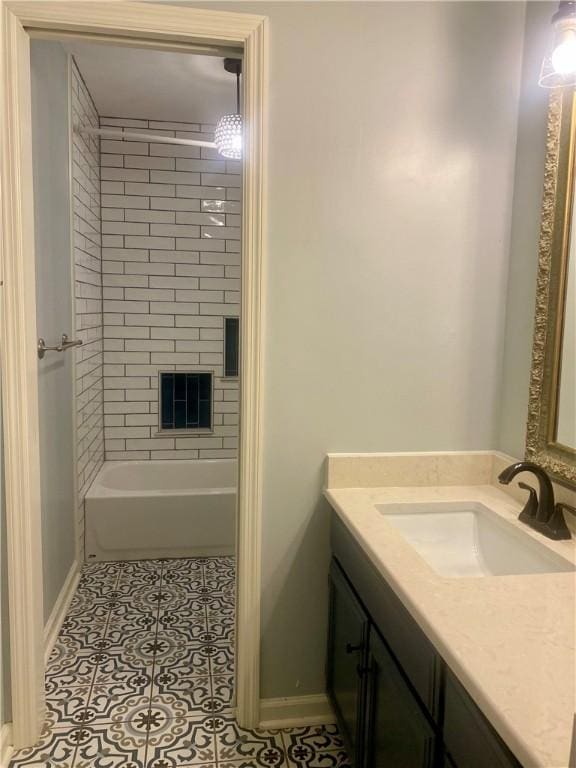 bathroom with tile patterned flooring, tiled shower / bath combo, and vanity