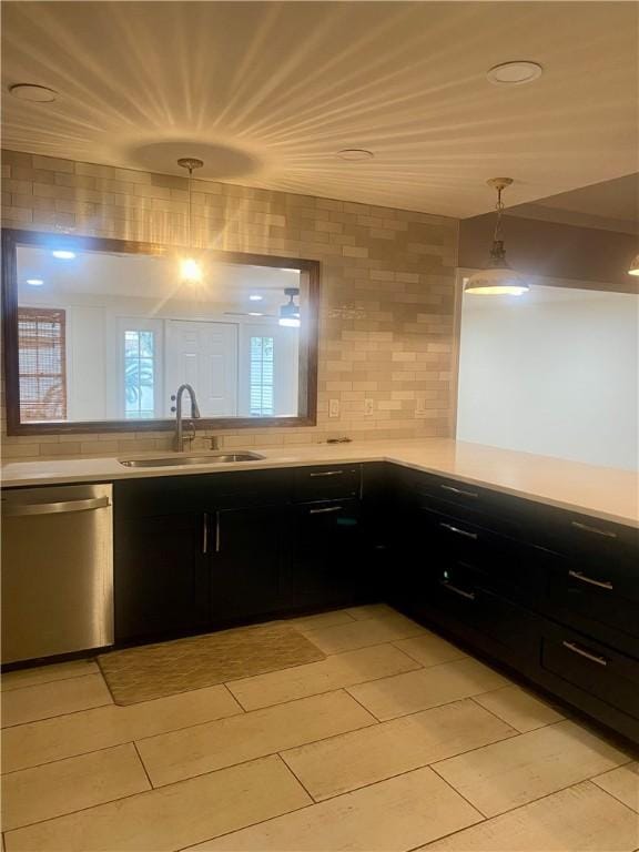 kitchen featuring backsplash, pendant lighting, sink, and stainless steel dishwasher