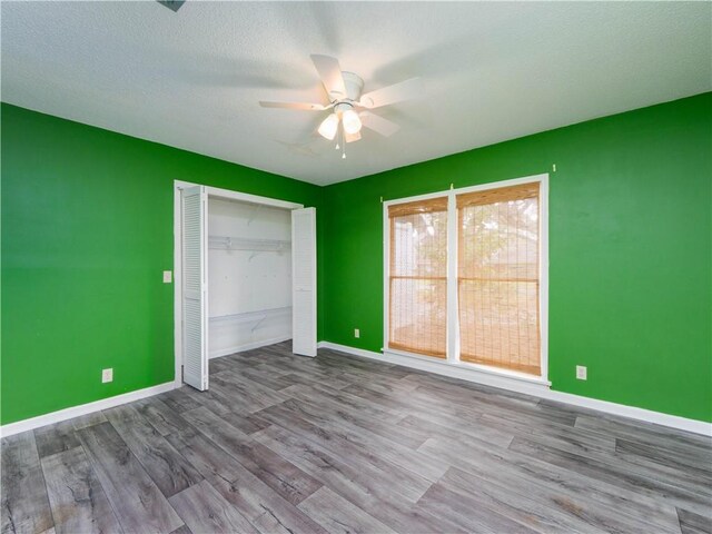 unfurnished bedroom with light wood-type flooring, a closet, ceiling fan, and a textured ceiling