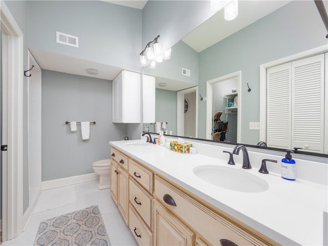 bathroom with tile patterned floors, toilet, a closet, and a sink