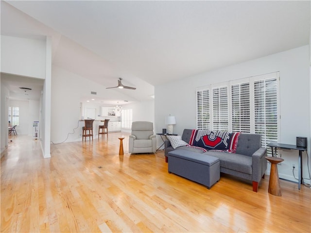 living area featuring a ceiling fan, plenty of natural light, and wood finished floors