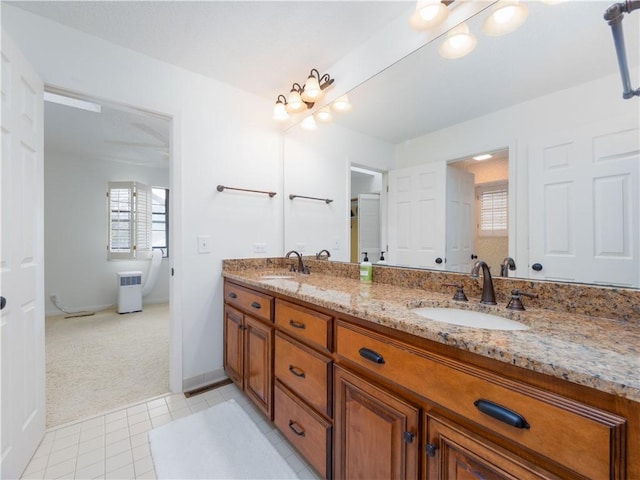 full bath with double vanity, baseboards, tile patterned floors, and a sink