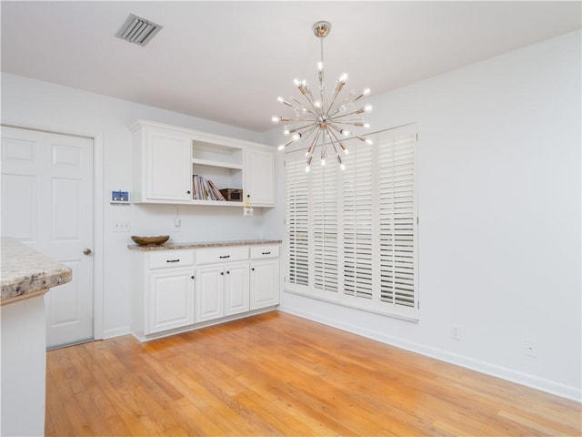 kitchen featuring visible vents, light wood-style floors, an inviting chandelier, white cabinetry, and open shelves