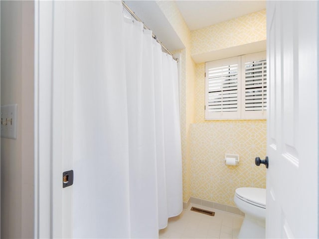 bathroom with tile patterned floors, visible vents, toilet, and wallpapered walls