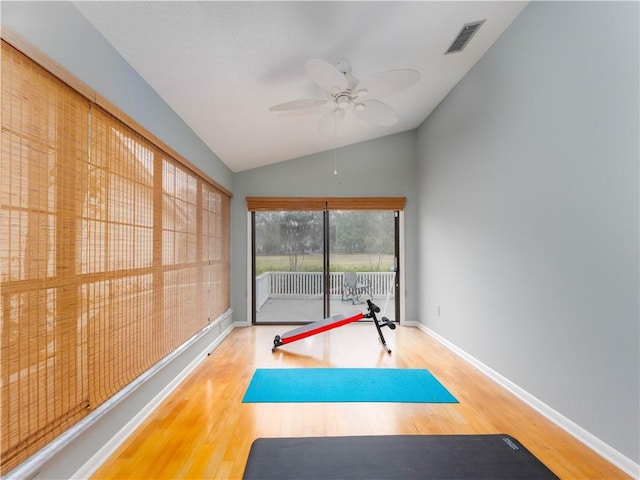 workout room with visible vents, wood finished floors, baseboards, lofted ceiling, and ceiling fan