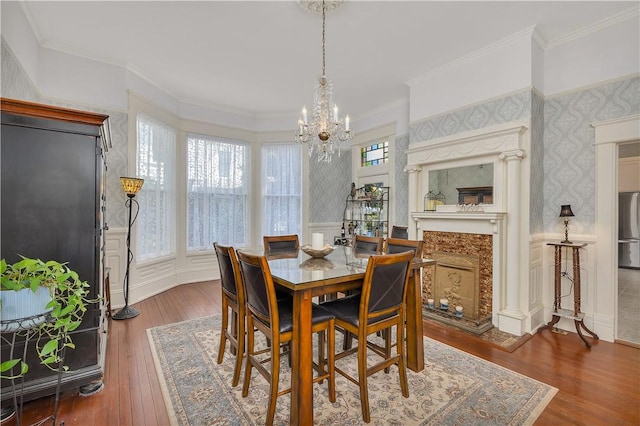 1000 Union St, Brunswick, GA 31520 - dining room with a chandelier, a wainscoted wall, wood finished floors, wallpapered walls, and crown molding