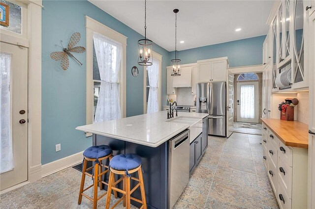 1000 Union St, Brunswick, GA 31520 - kitchen featuring stainless steel appliances, white cabinets, a breakfast bar, butcher block counters, and hanging light fixtures